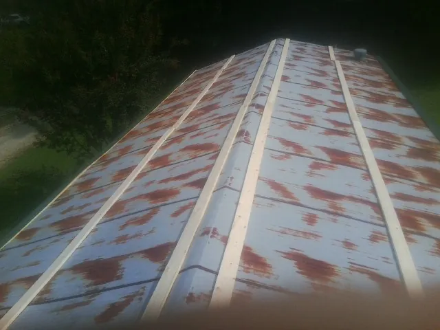 Rusted metal roof panels with new wood purlins before replacement — Storm Damage Roof Repair in Summit by Roofing Brothers